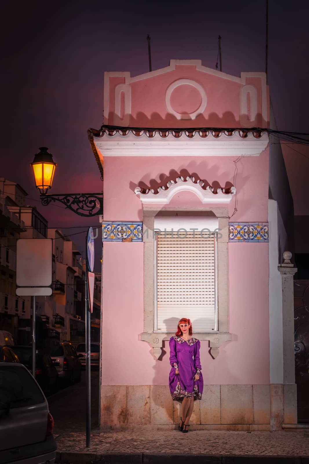 Close up view of a young redhead girl on a retro vintage dress on the urban city.