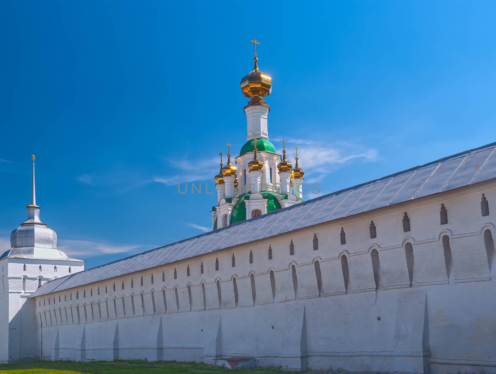 White  Ortodox monastery with gold domesl in sunny spring day