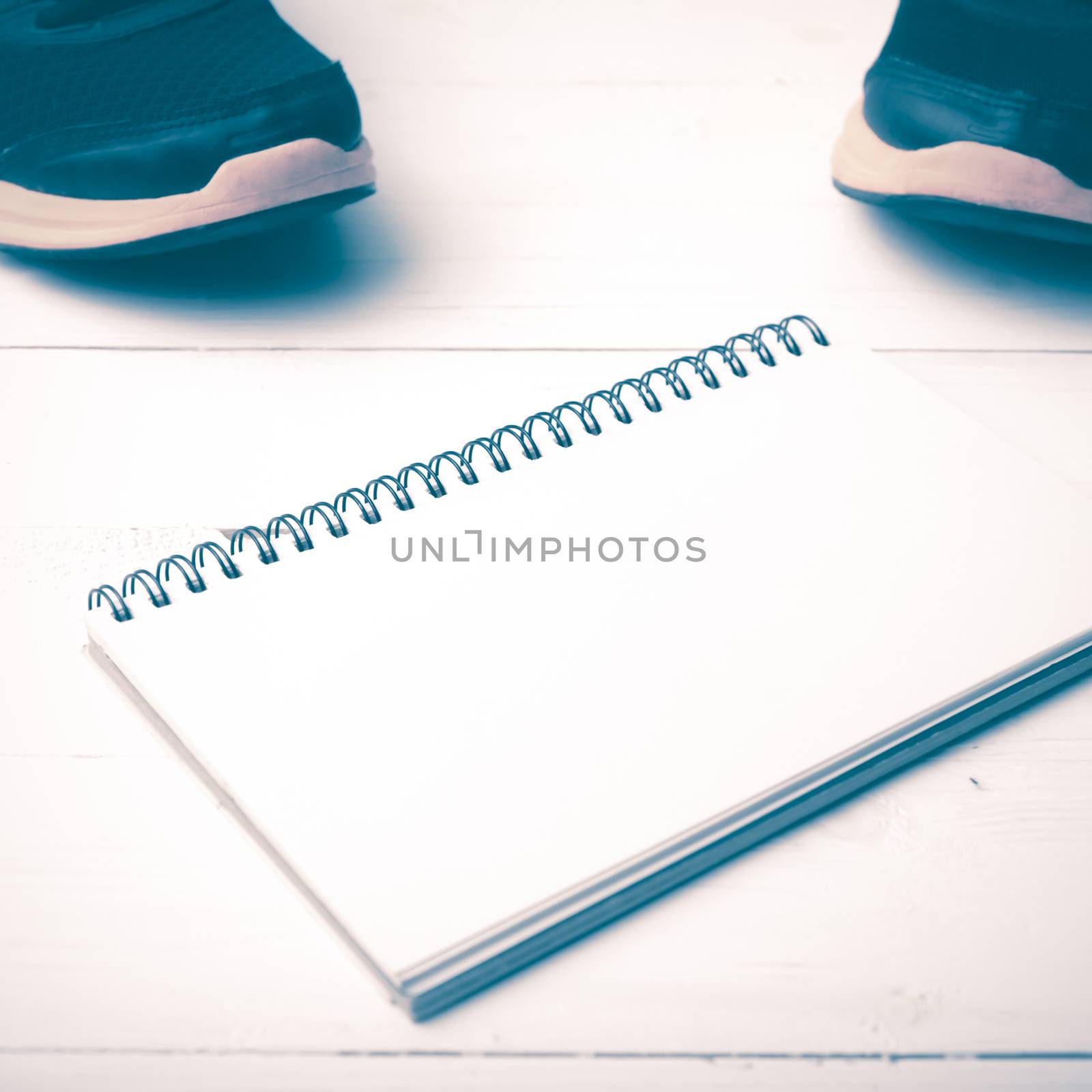running shoes and notepad on white wood table vintage style