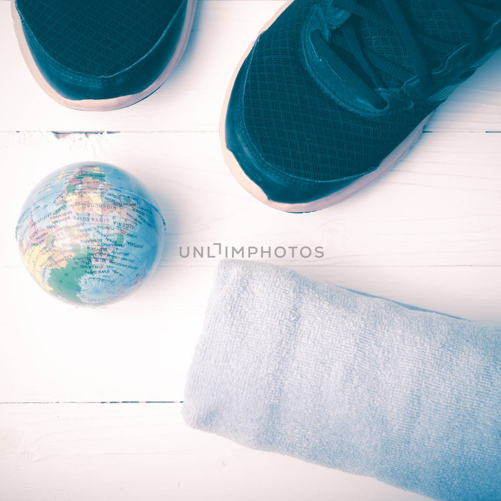running shoes,towel and earth ball on white wood table concept world healthy vintage style