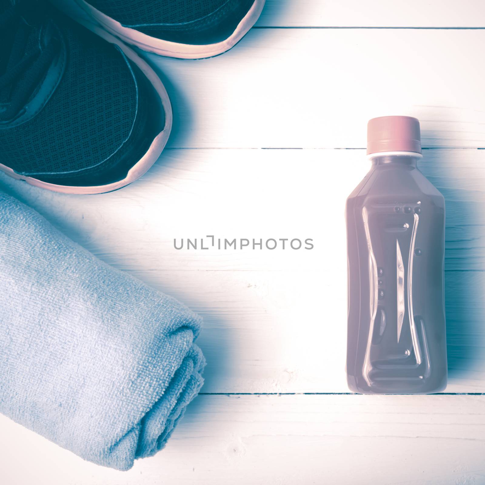 running shoes,towel and orange juice on white wood table vintage style