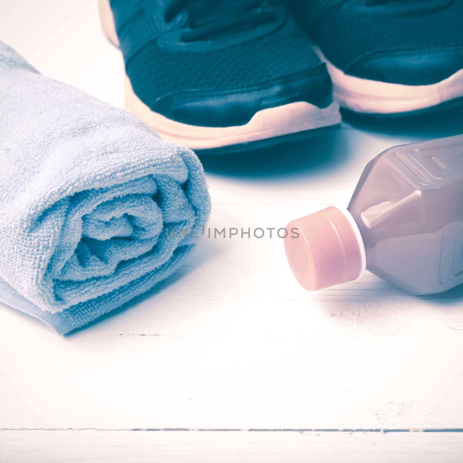 running shoes,towel and orange juice on white wood table vintage style