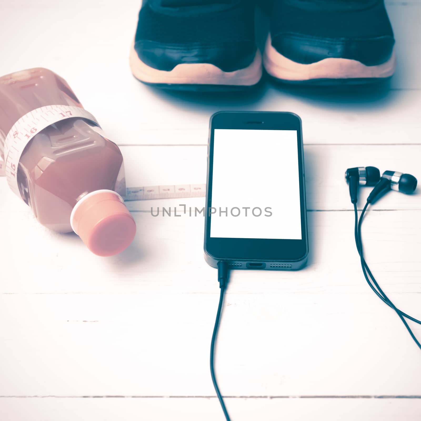 running shoes,orange juice,measuring tape and phone on white wood background vintage tone color style