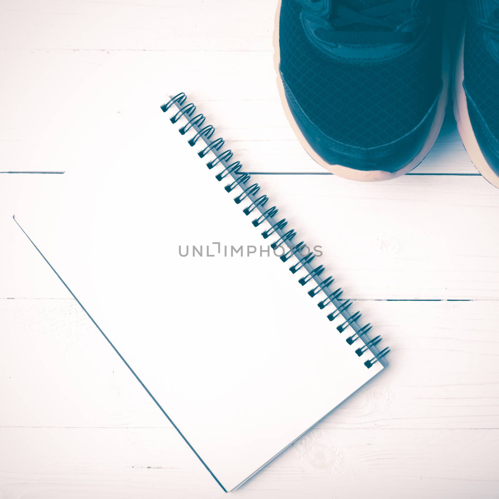 running shoes and notepad on white wood table vintage style