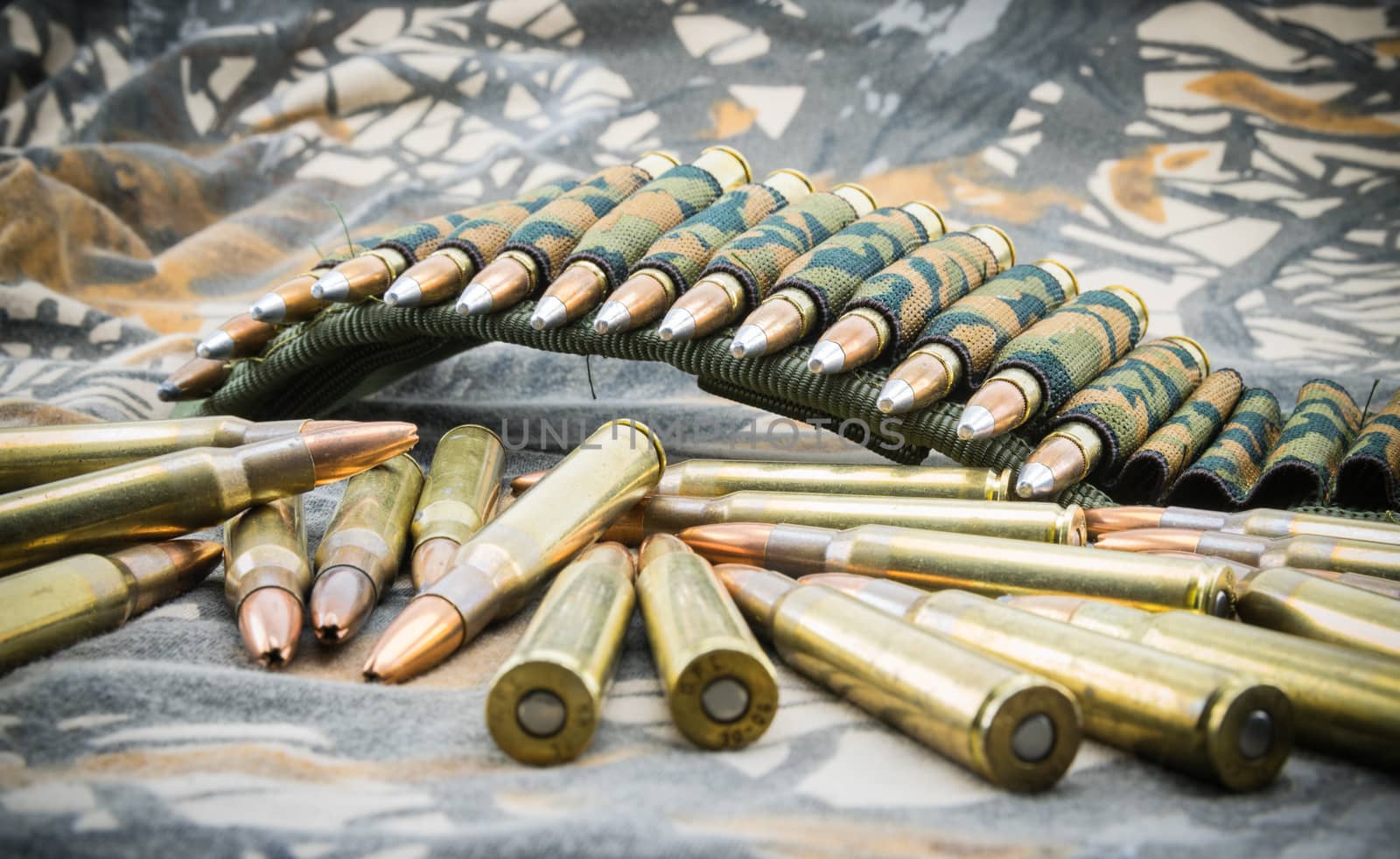 hollow point ammunitions for rifle on camouflage background.