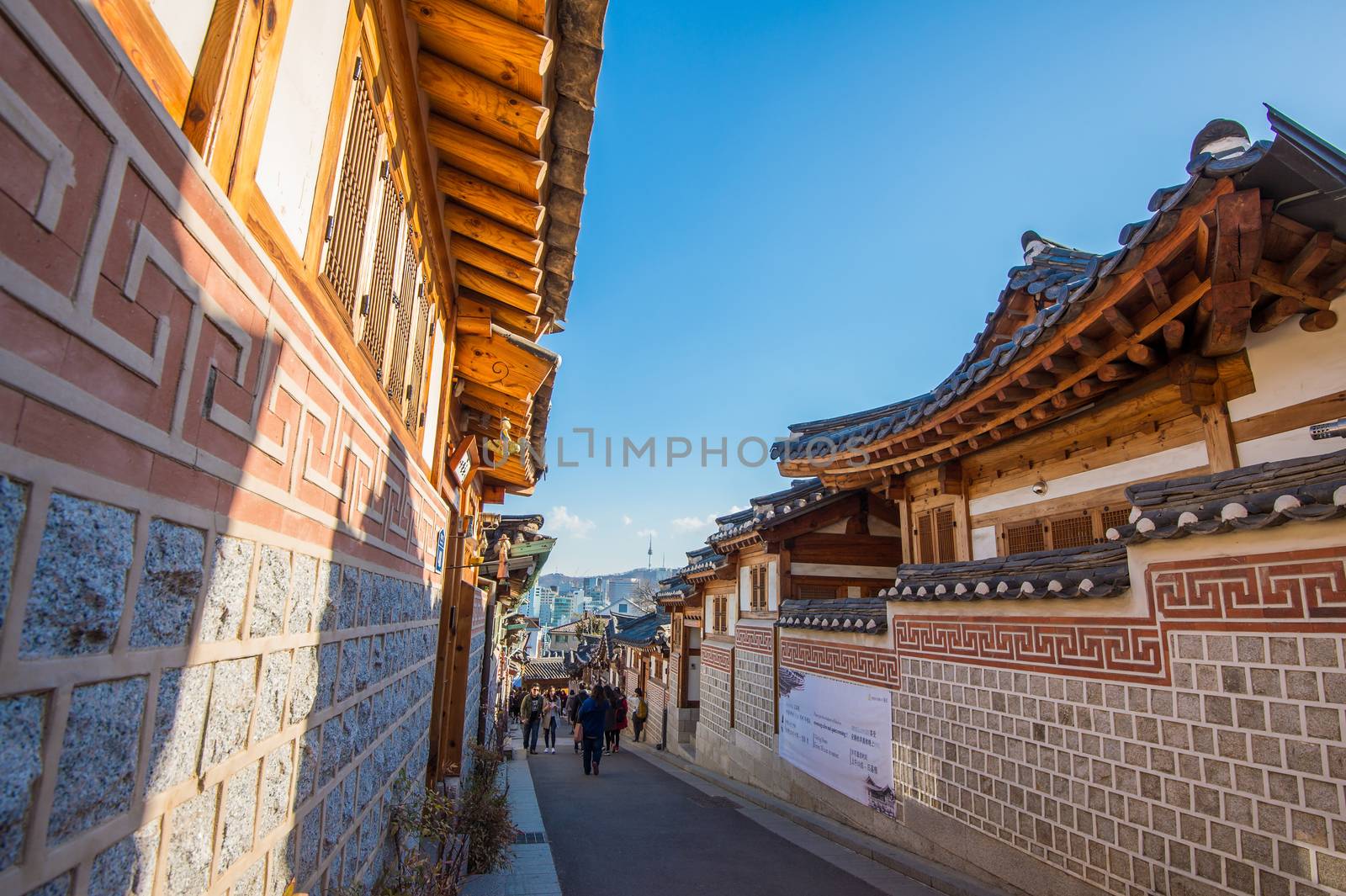 Tourists taking photos of the beautiful scenery around Bukchon Hanok Village,Traditional Korean style architecture. by gutarphotoghaphy