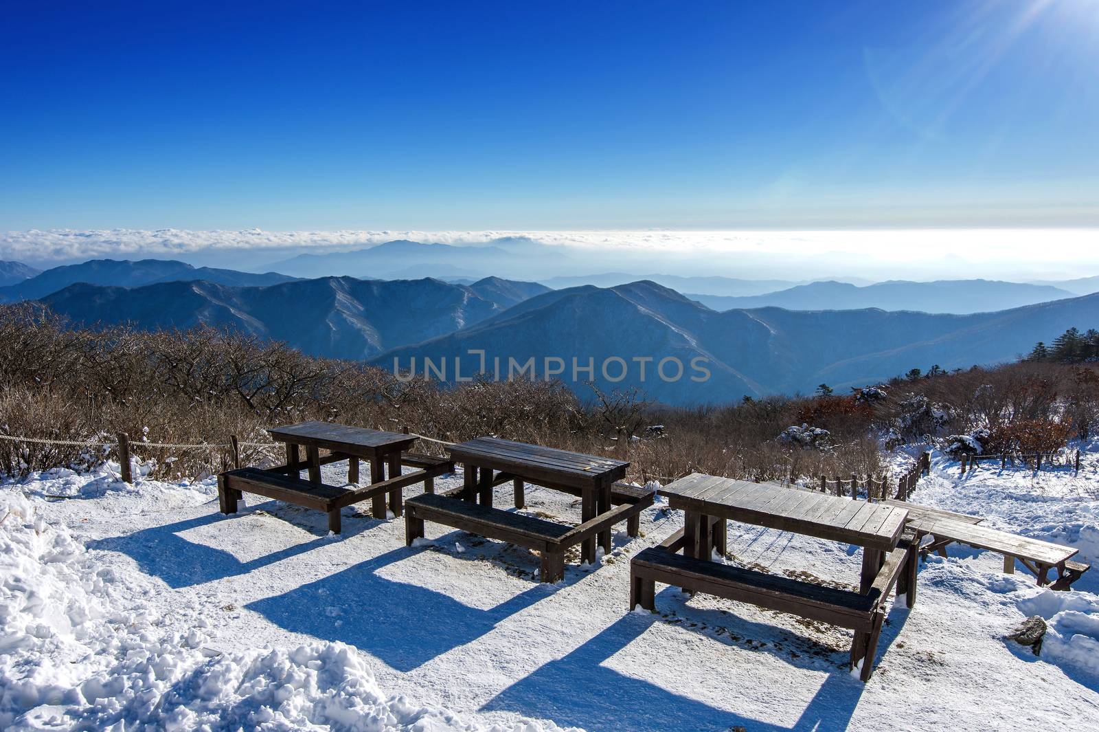 Wooden picnic tables with benches in winter,Deogyusan Mountains, South Korea. by gutarphotoghaphy