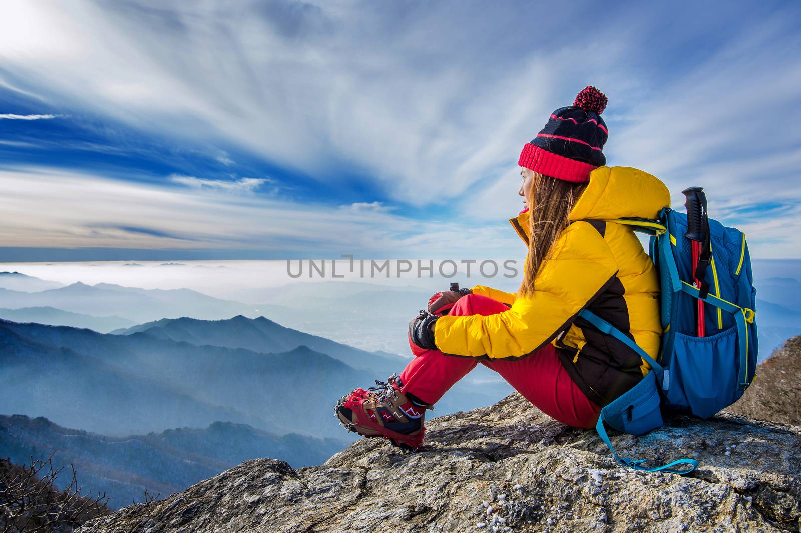 Young woman sitting on the hill of high mountains. by gutarphotoghaphy