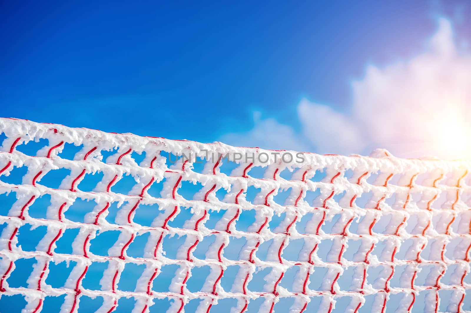 Frozen and snow covered protective net on skiing track. Concept of winter.