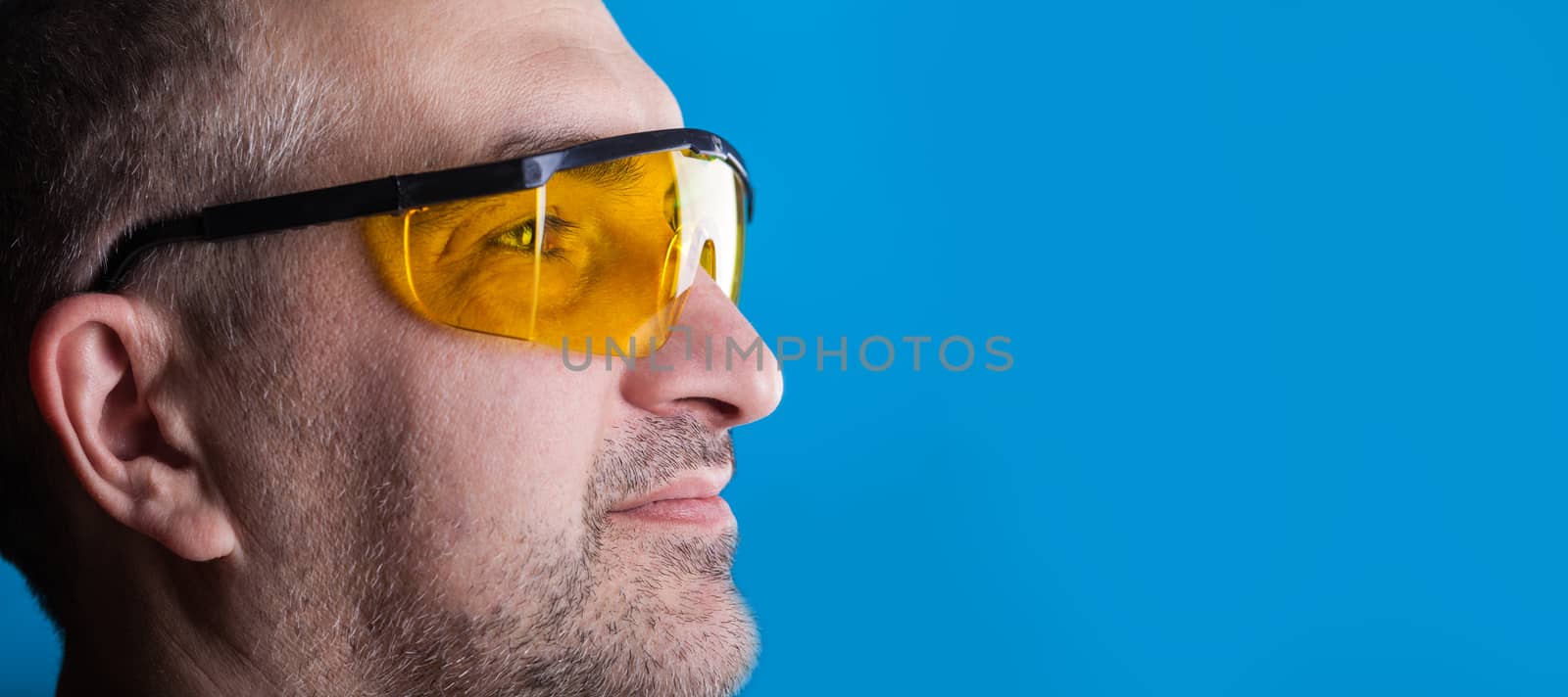 man in glasses working on a blue background