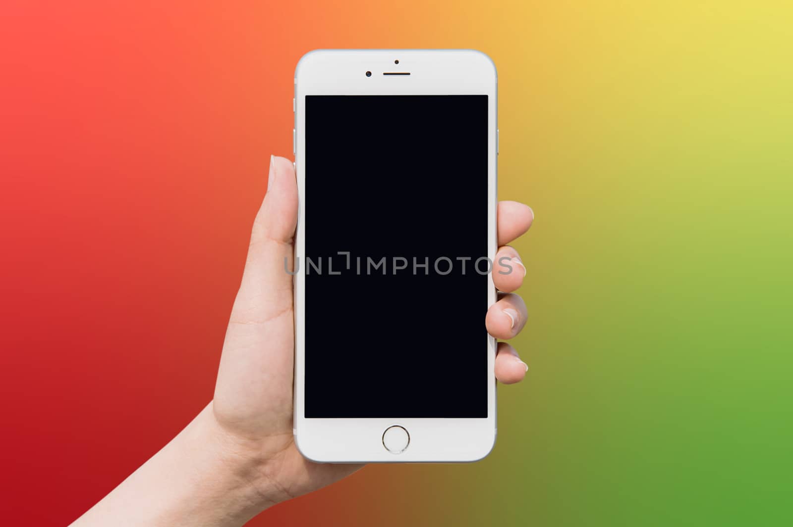 Hand holding smart phone on colorful blur background.

