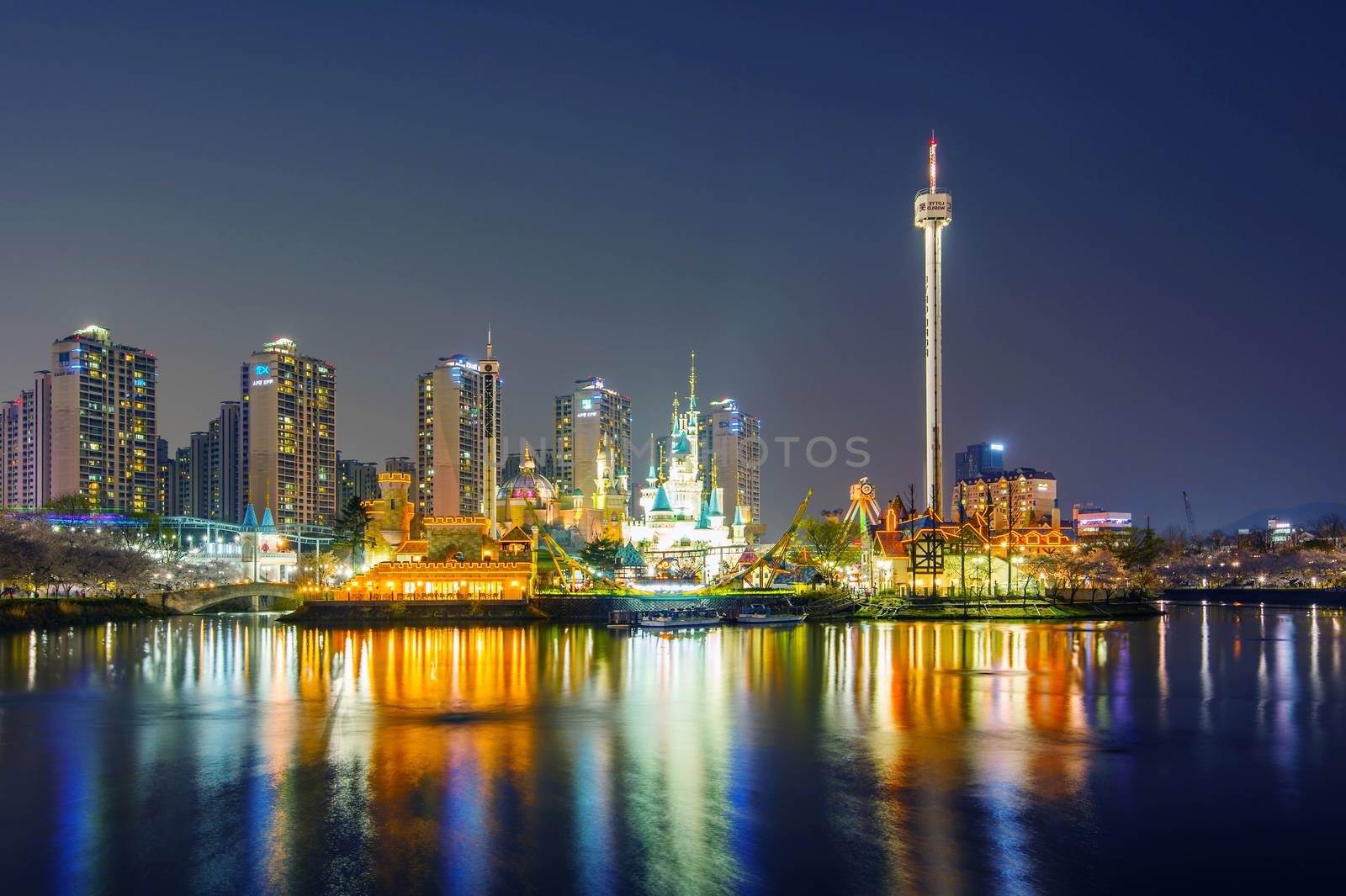 SEOUL, KOREA - APRIL 9, 2015: Lotte World amusement park at night and cherry blossom of Spring, a major tourist attraction in Seoul, South Korea on April 9, 2015