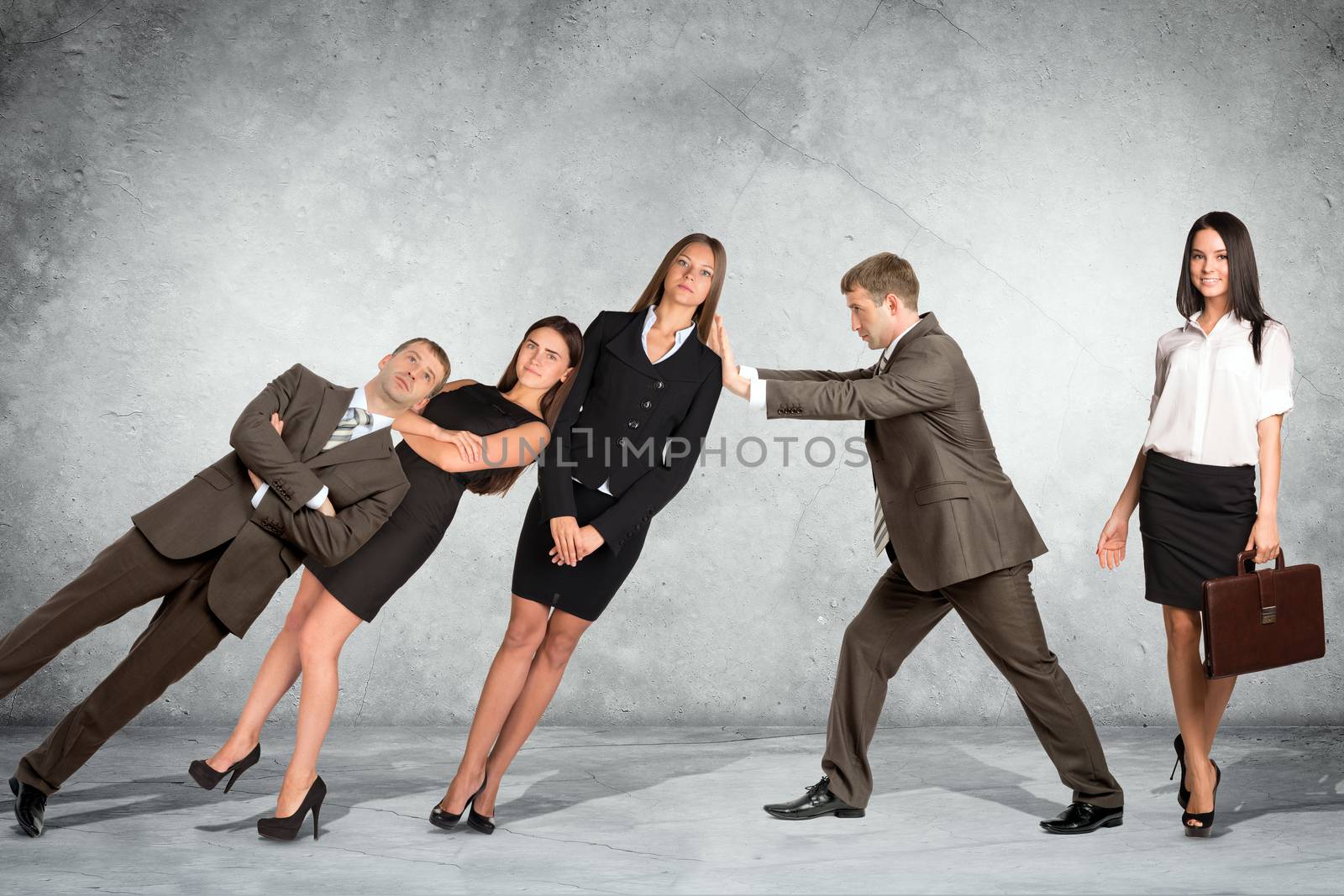 Businessman supporting falling business people on wall background, co-working concept