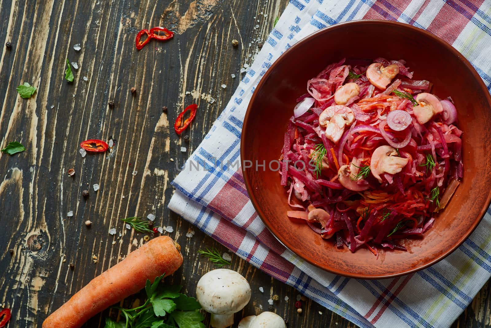 A bowl with salad on the rustic rough wooden board