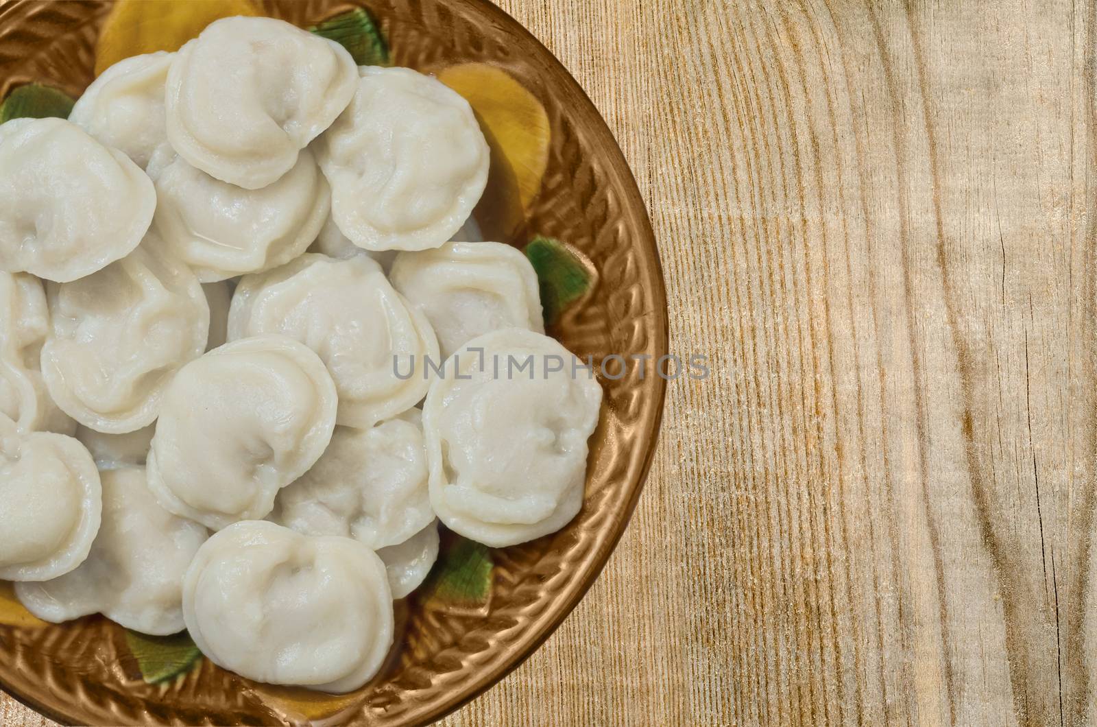 The finished dish of stuffed dough in ceramic bowl on wooden background