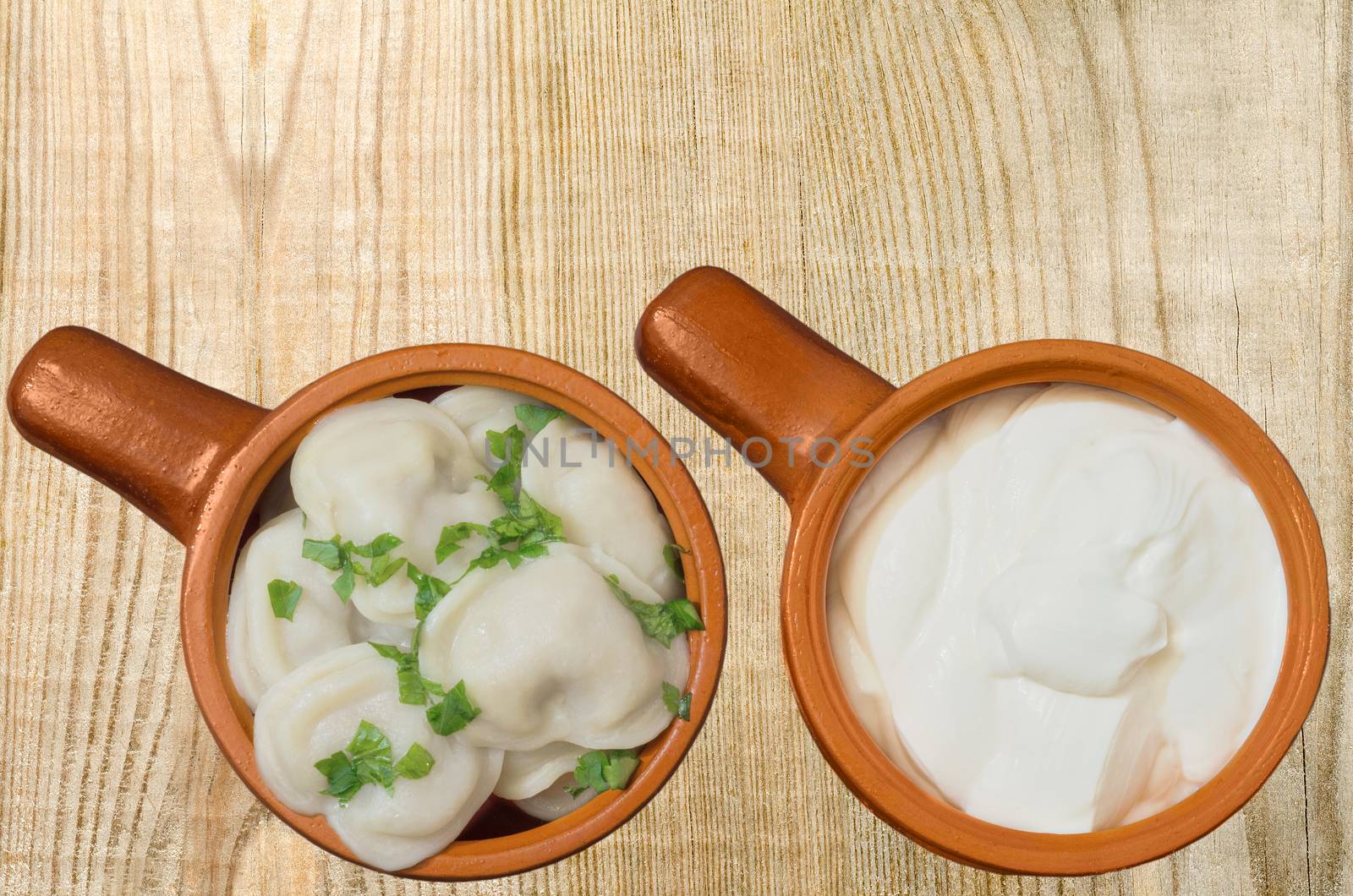 Boiled dumplings and sour cream in the dishes by Gaina