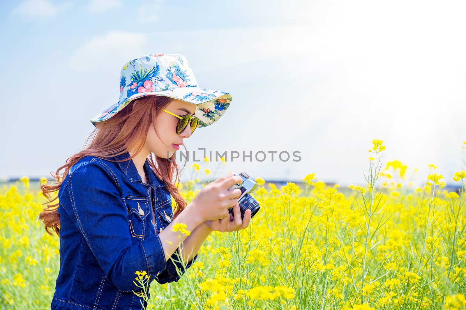 woman taking photos at a rapeseed flowers by gutarphotoghaphy