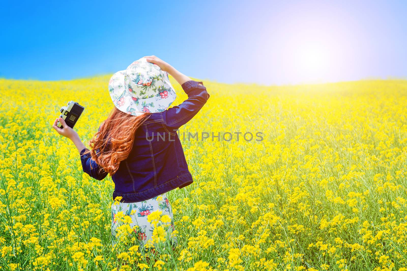 Young woman standing in yellow rapeseed field. by gutarphotoghaphy