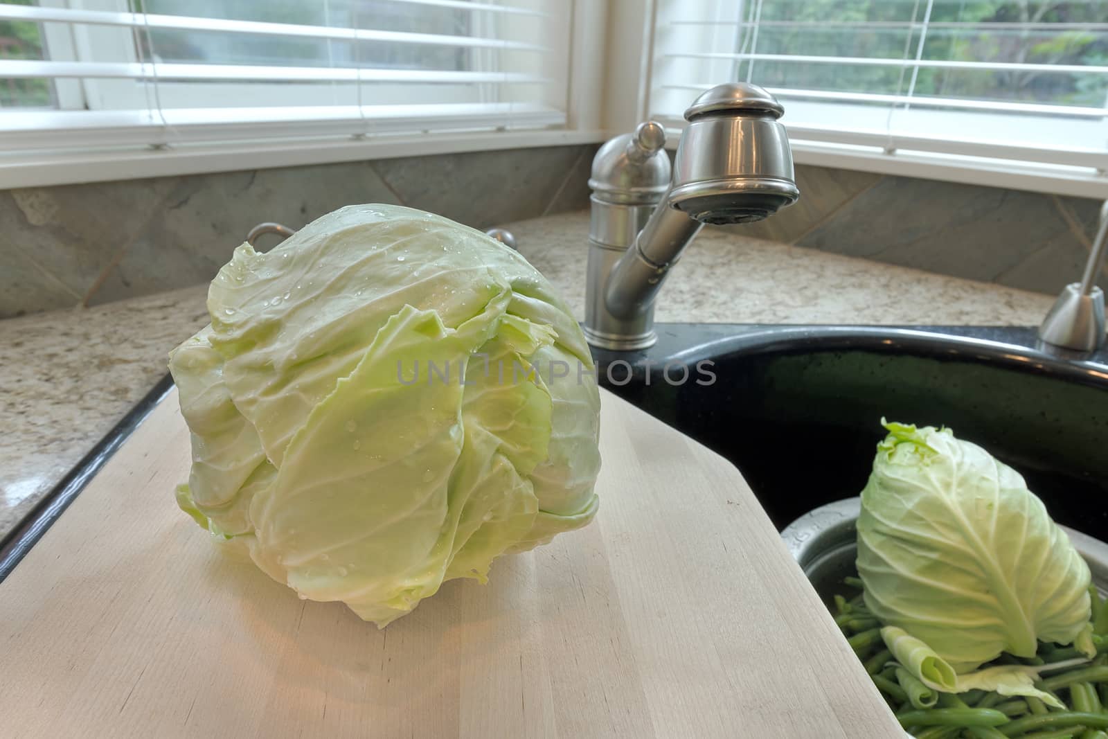 Head of Cabbage on Chopping Board over Kitchen Sink