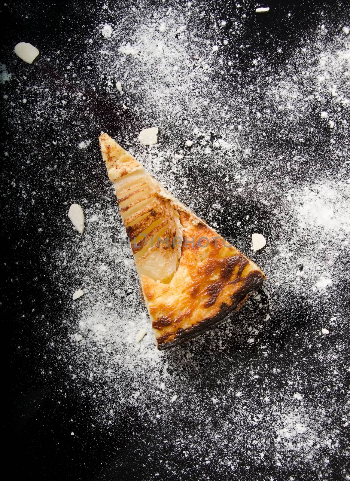 Piece of sweet tasty pear pie on black table.