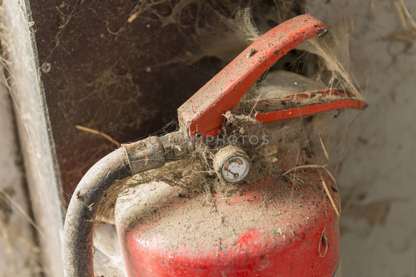 Old dusty fire extinguisher in a barn
