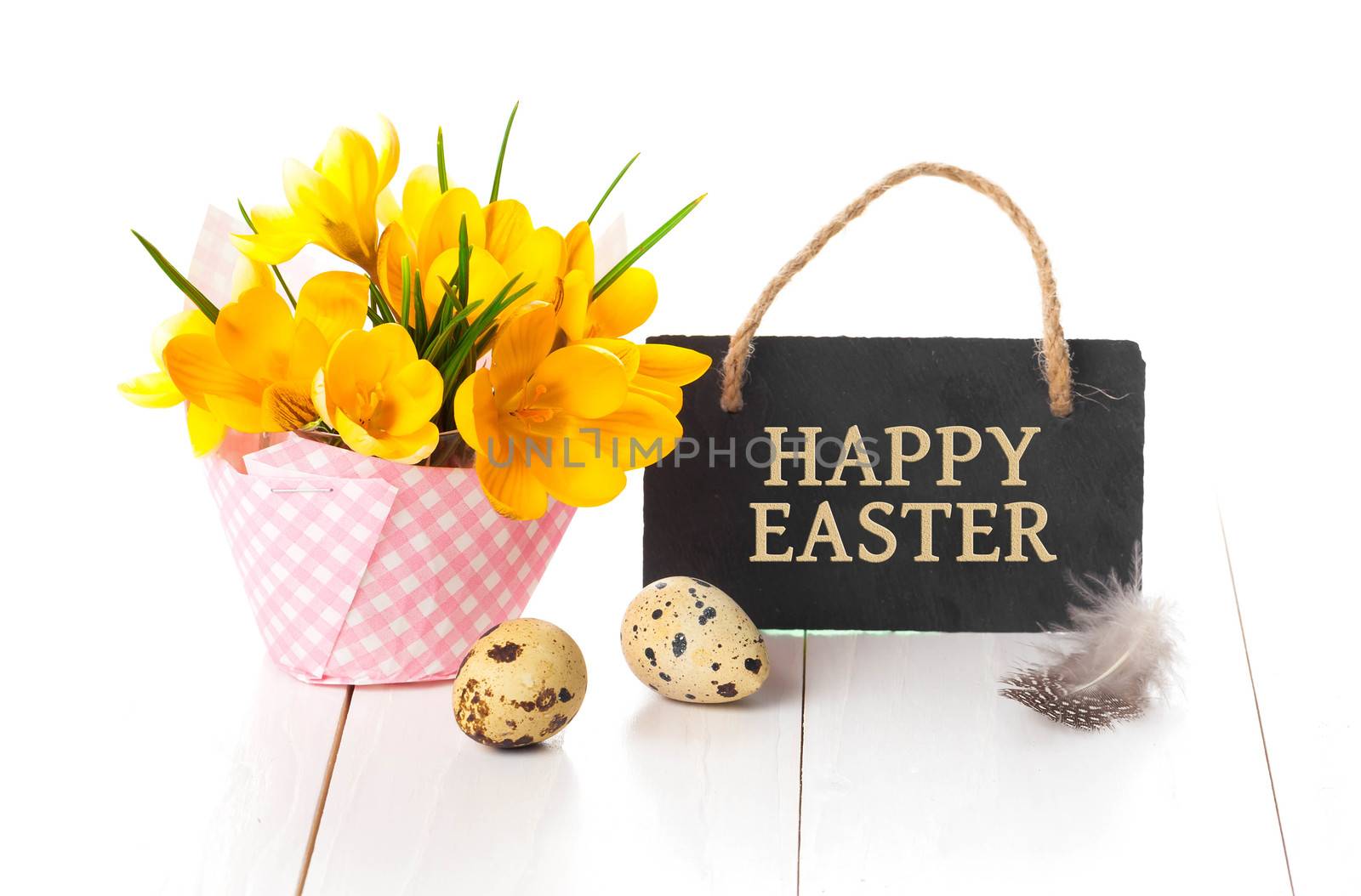 easter decoration with quail eggs, yellow Spring Crocus, and blackboard, with space for text, on wooden white background.