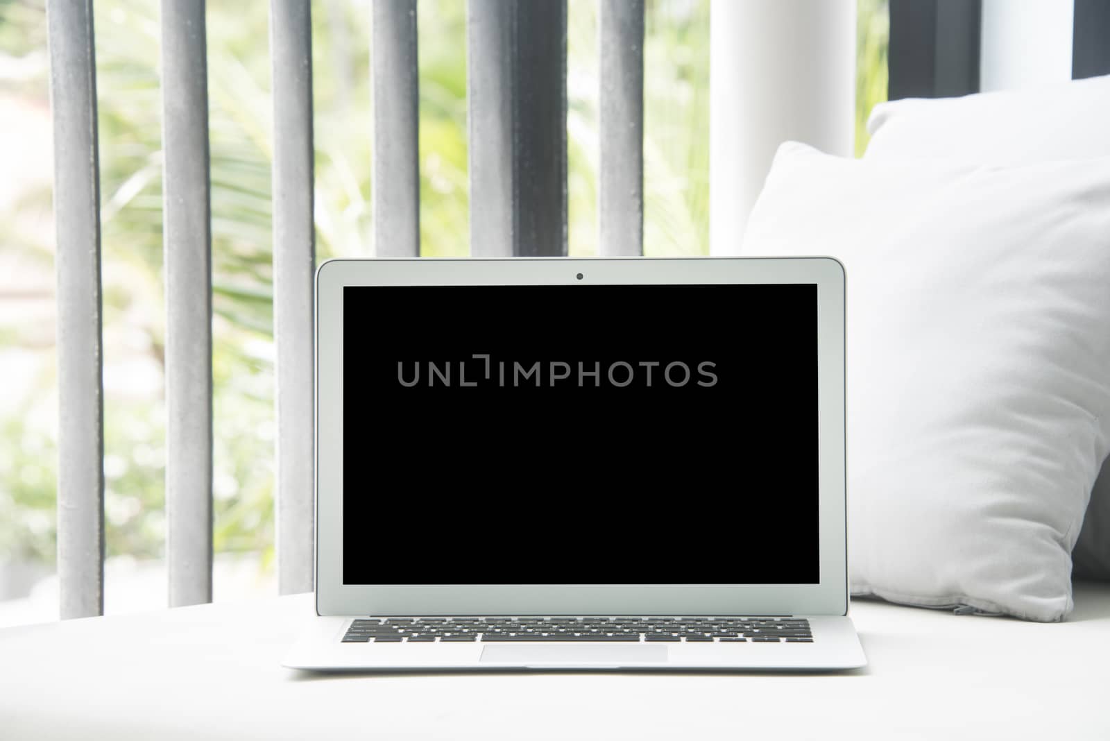 High-key image of Laptop on a chair and daybed.