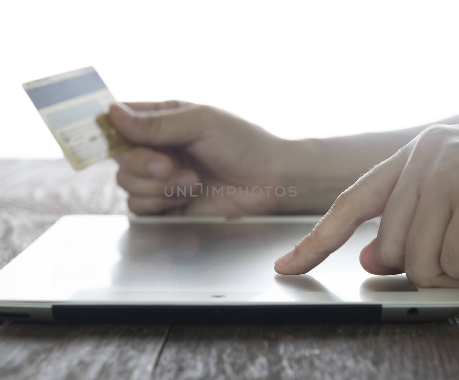 close-up women's hand using tablet pc for shopping online.