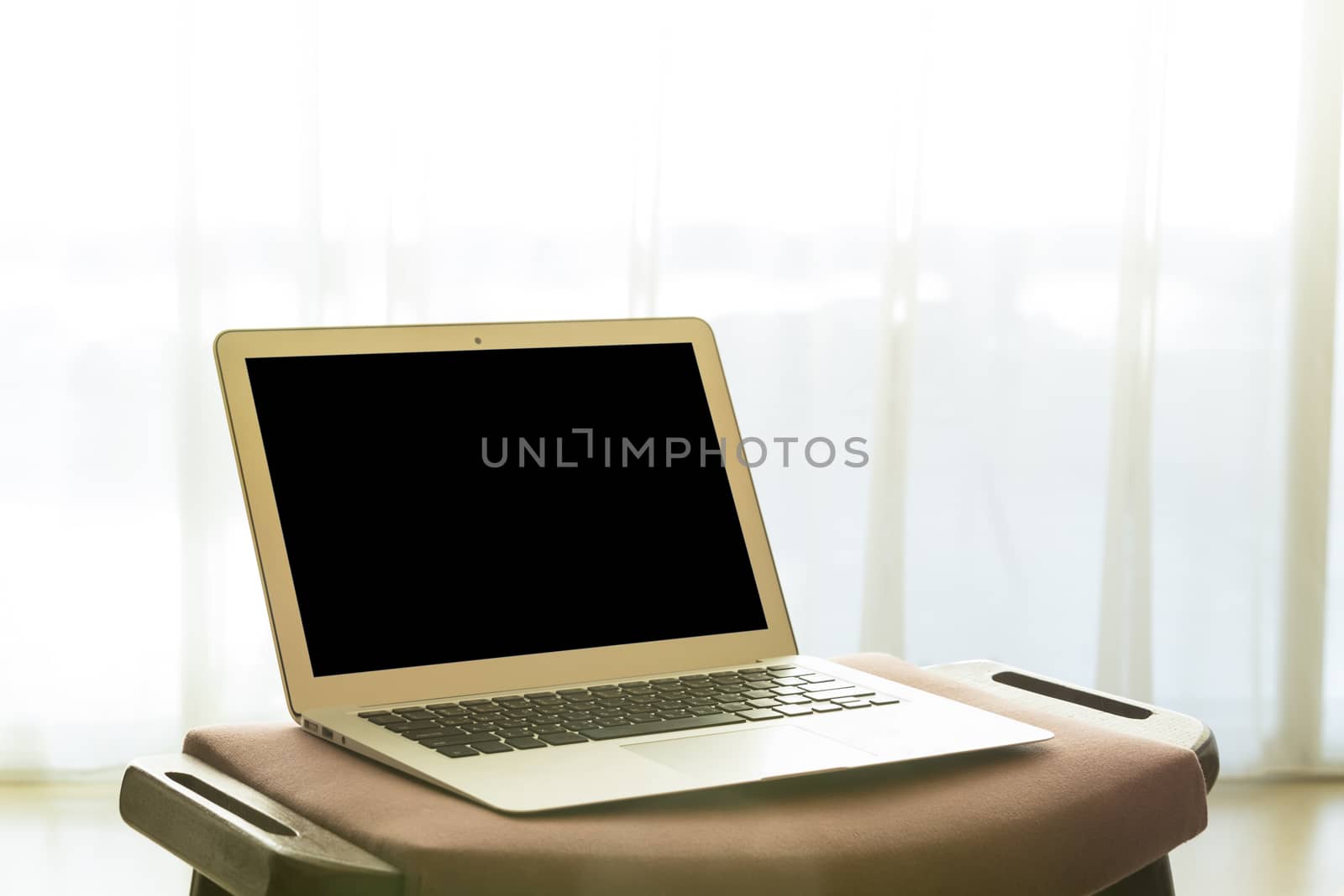 laptop computer and white curtains in bedroom. technology concept, freelance concept, business concept. Selective focus.