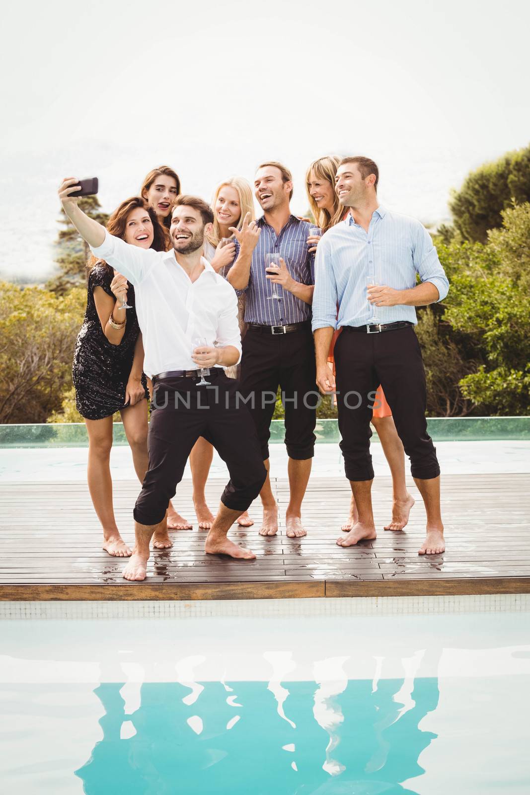 Group of friends taking a selfie near the swimming pool in a resort