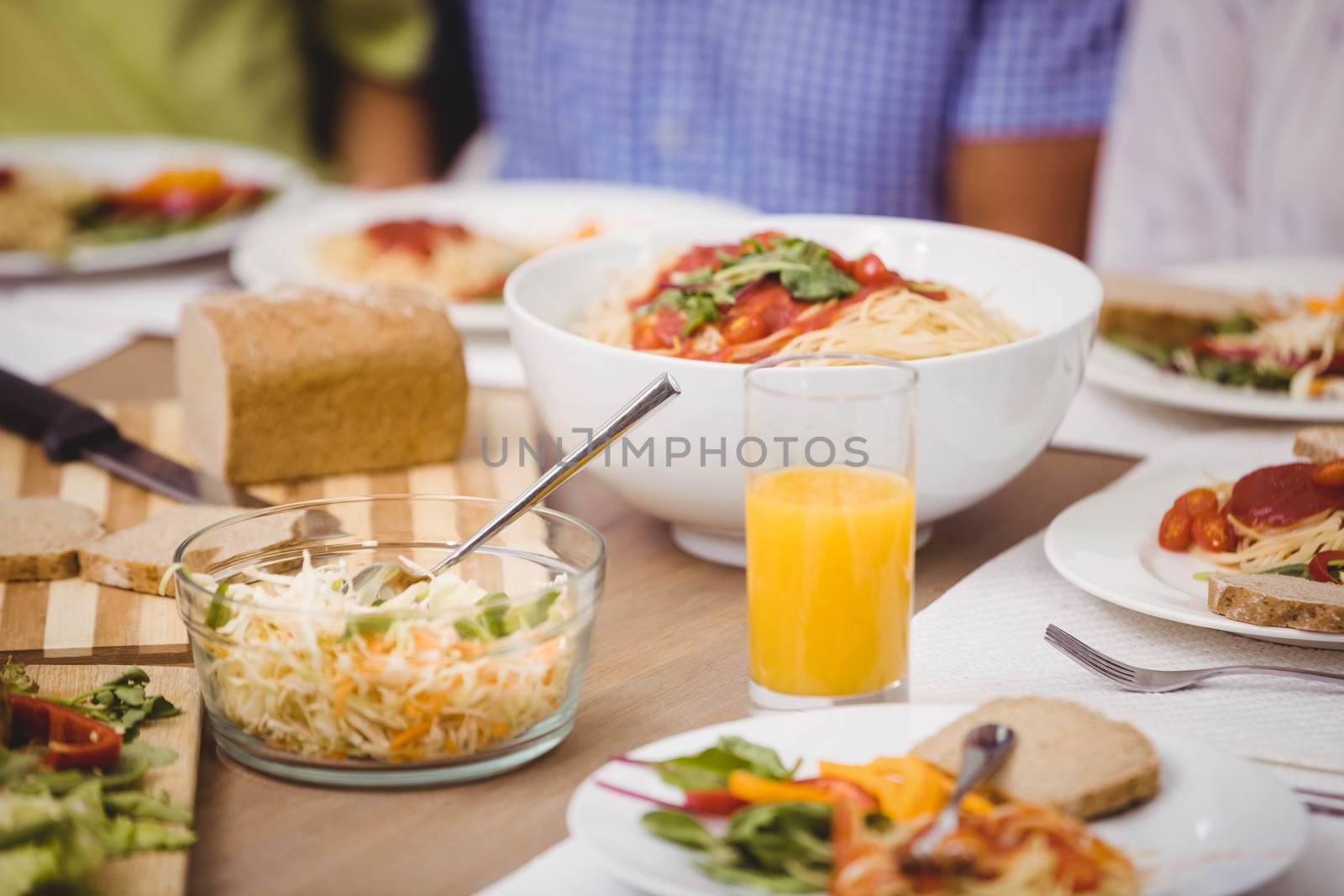 Various food on dining table while family having a meal together