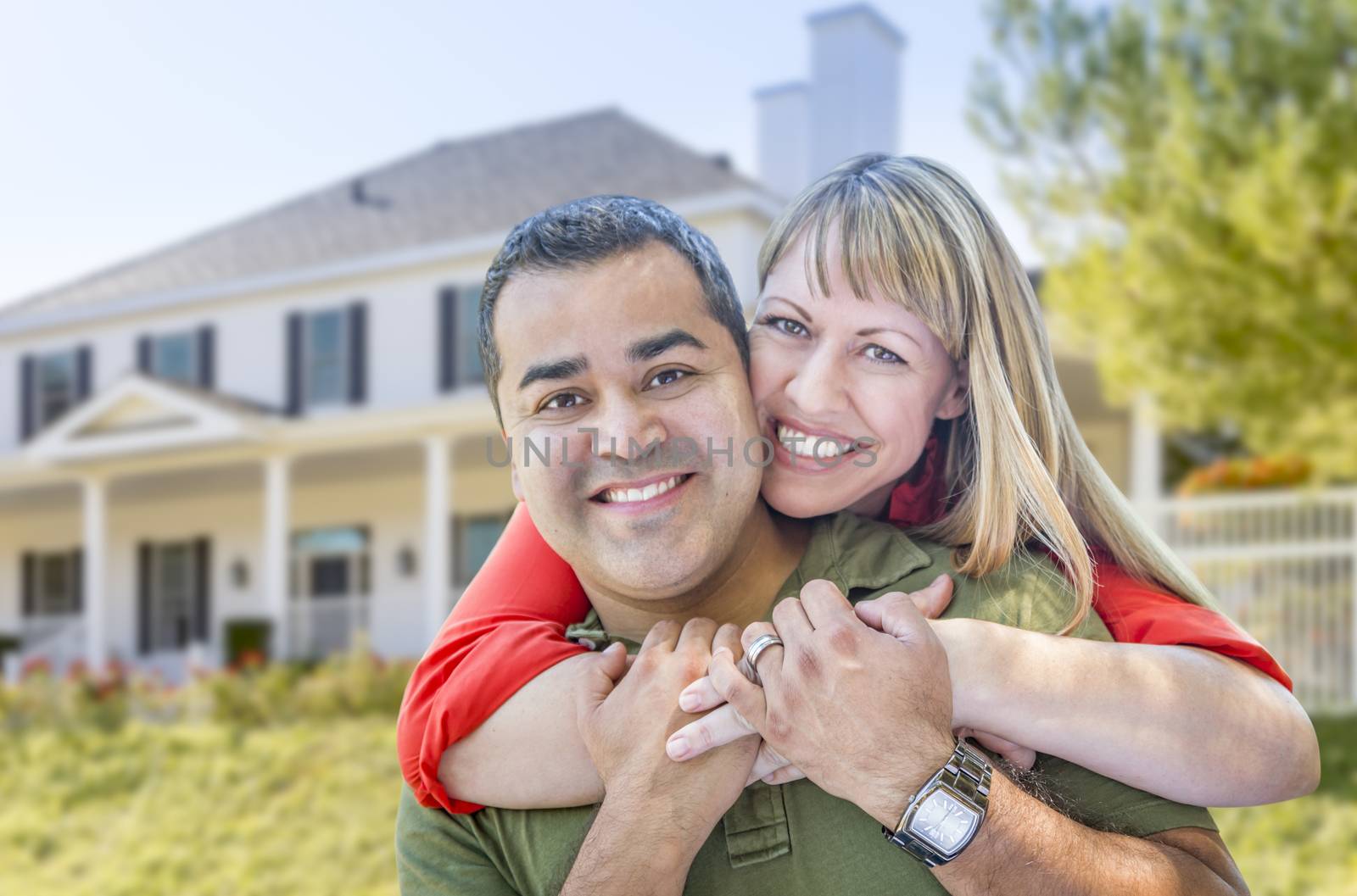 Happy Mixed Race Couple in Front of Beautiful House.