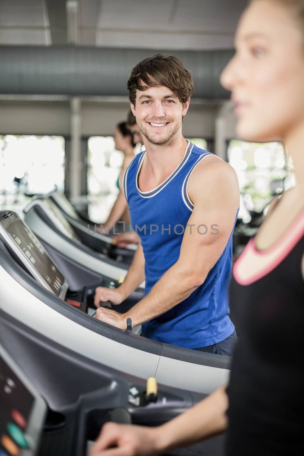 Athletic man running on treadmill at the gym