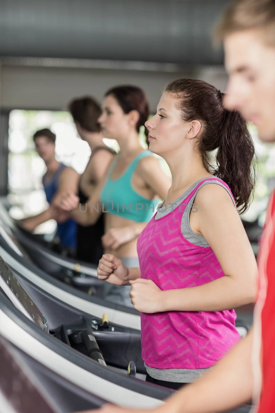 Smiling muscular woman on treadmill at gym 