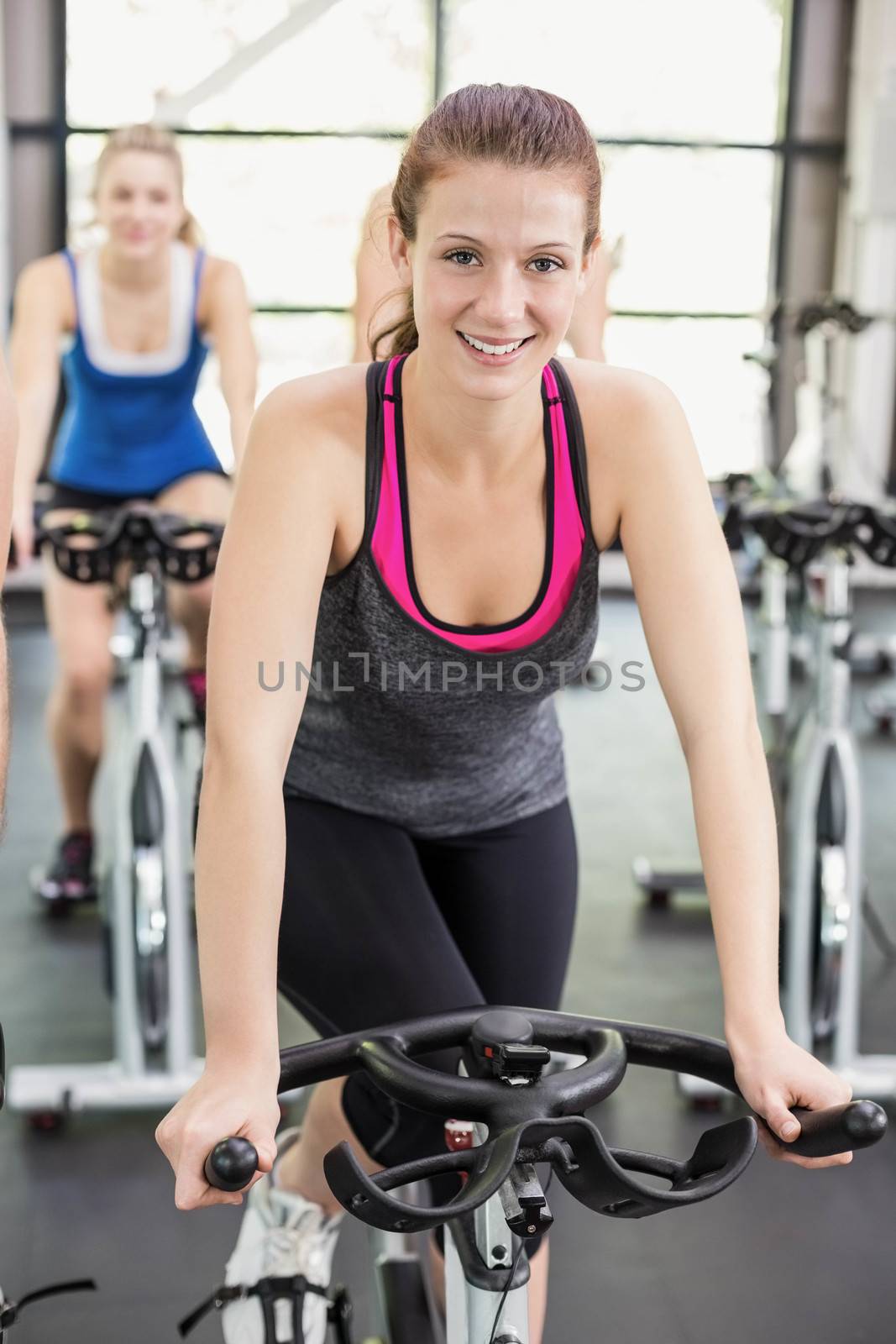 Fit group of people using exercise bike together by Wavebreakmedia