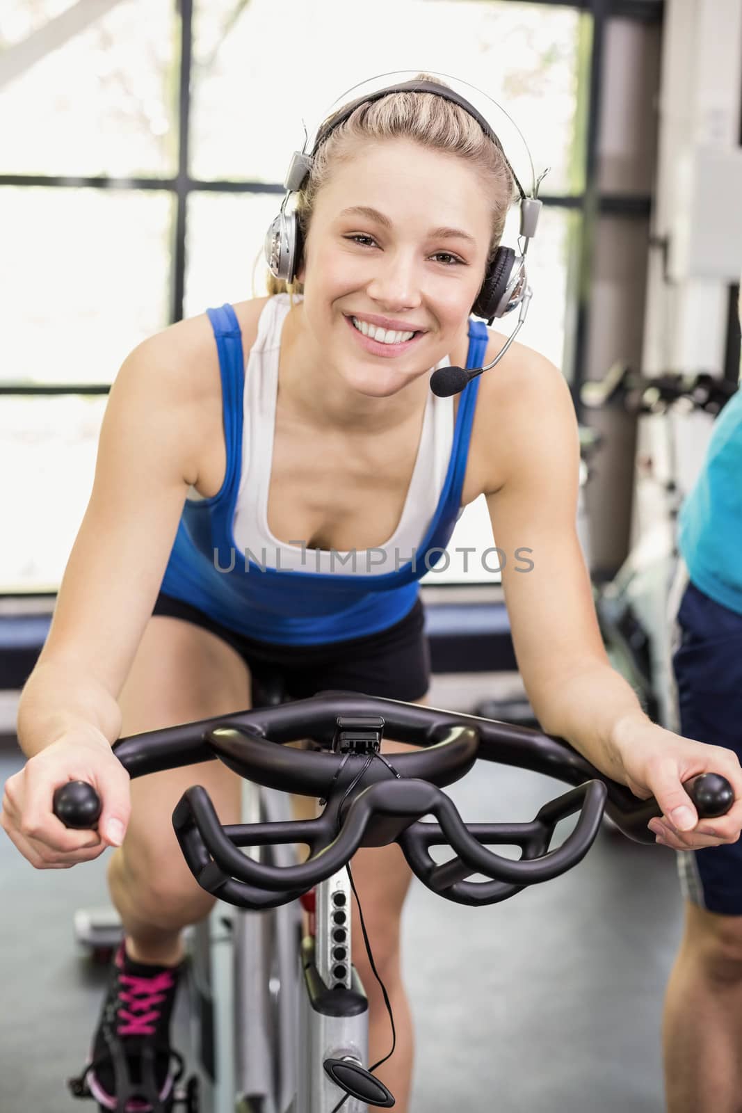 Fit group of people using exercise bike together by Wavebreakmedia