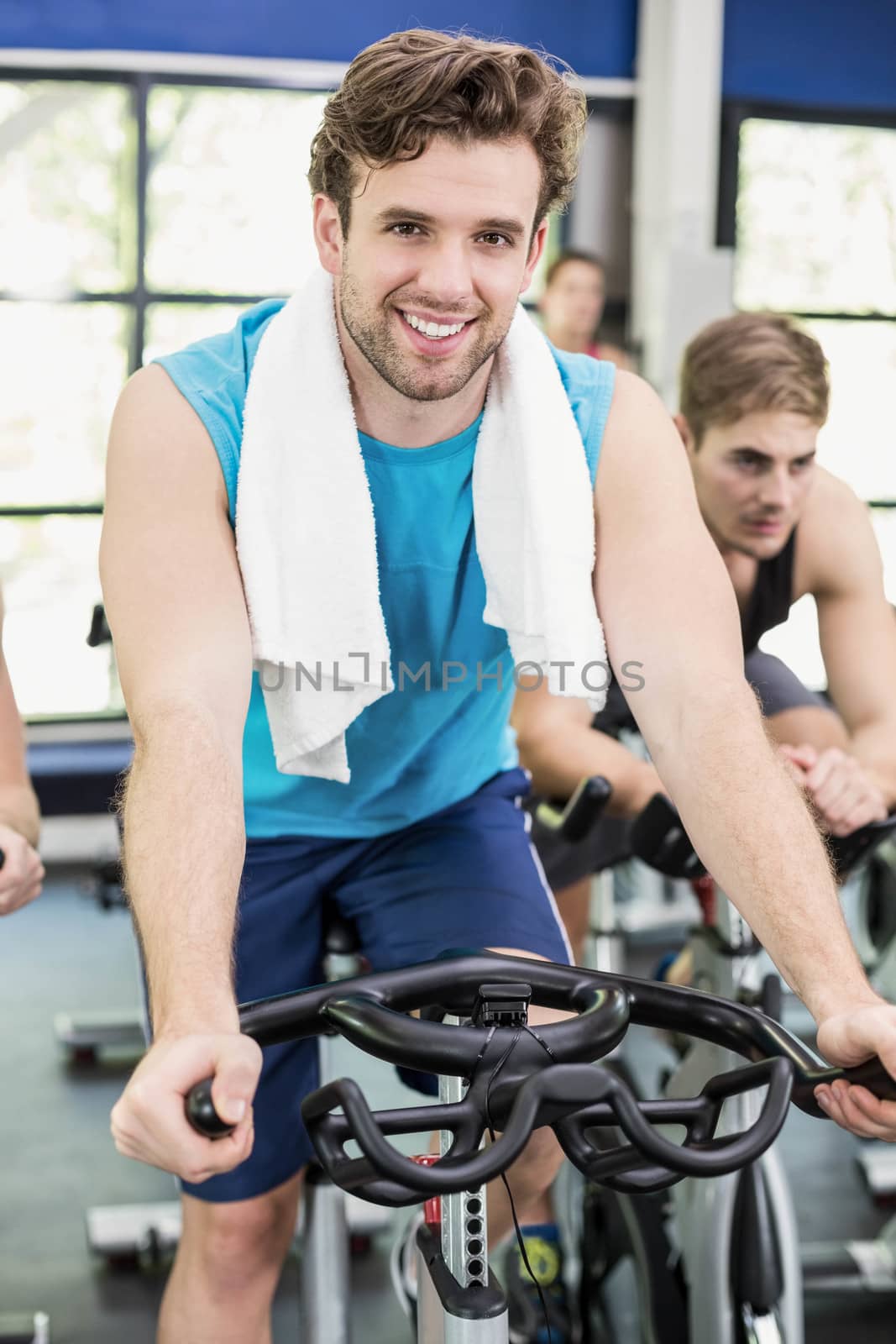 Fit group of people using exercise bike together by Wavebreakmedia