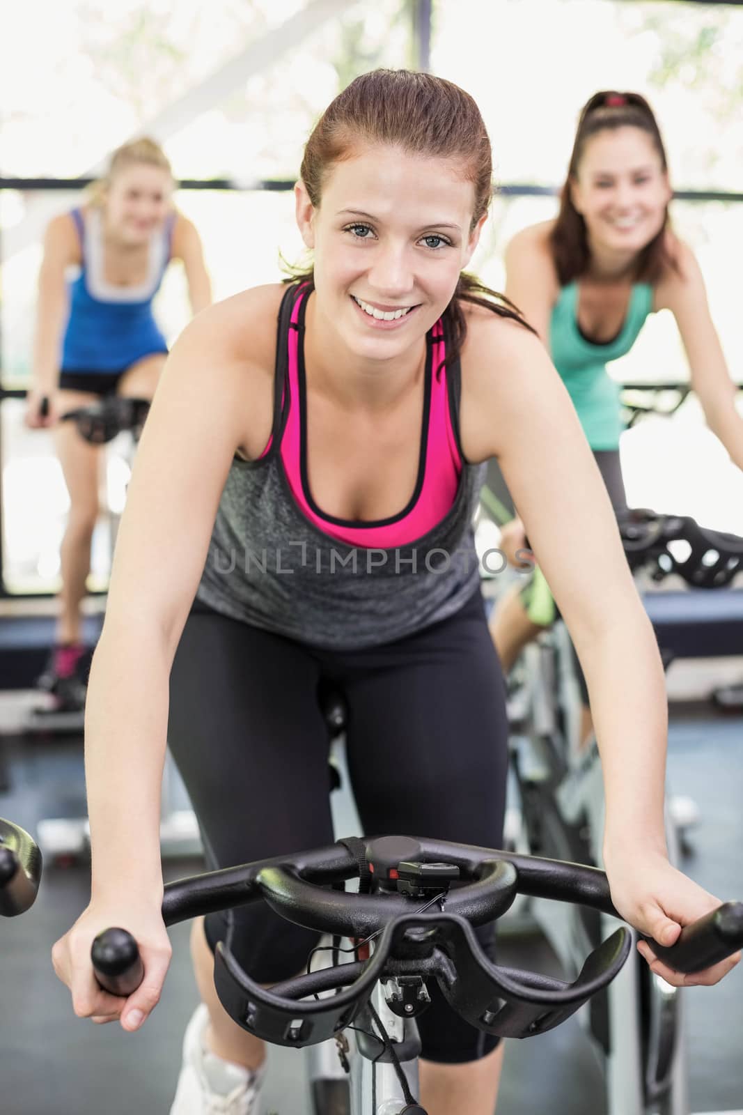 Fit group of people using exercise bike together by Wavebreakmedia