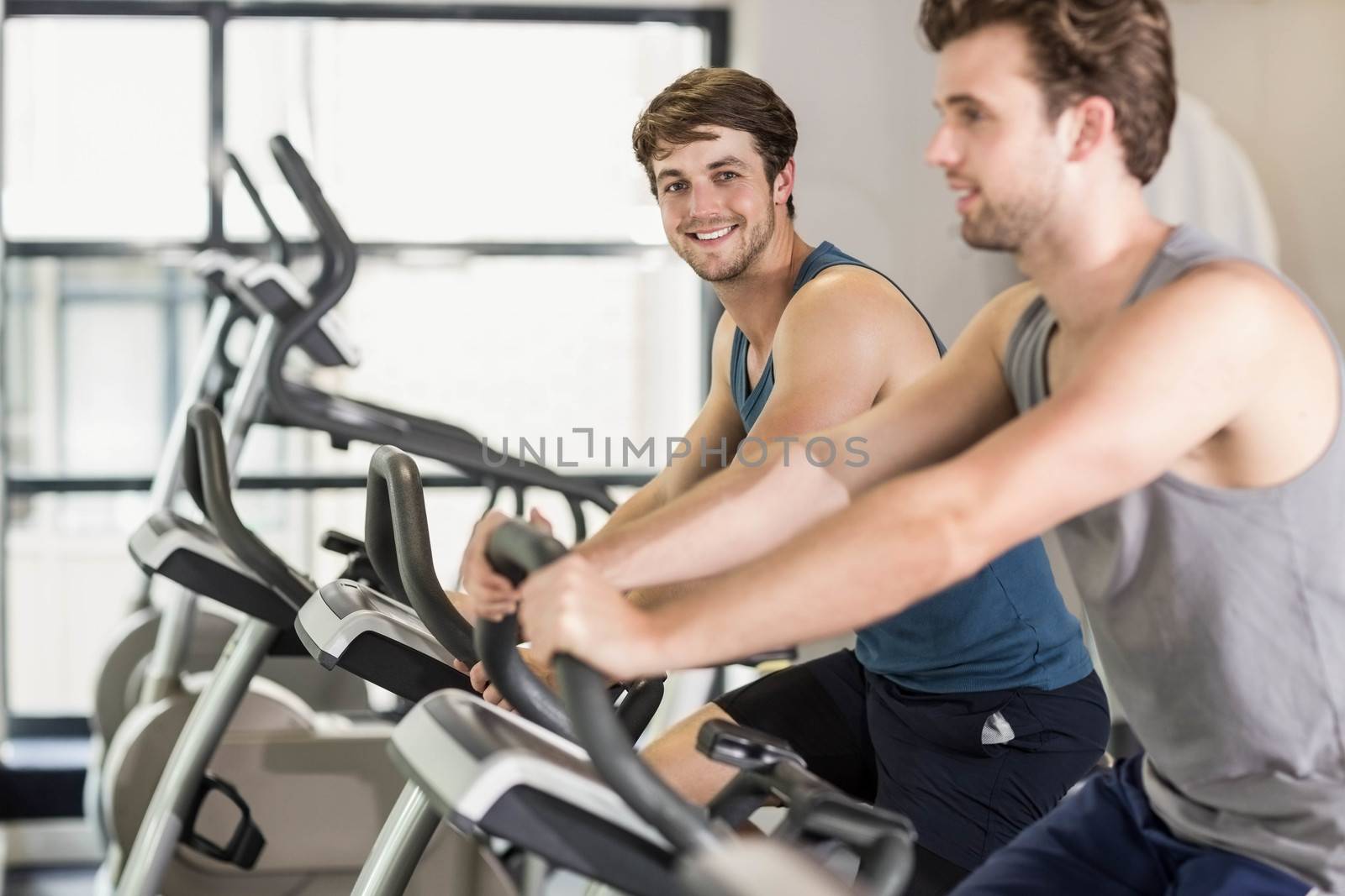 Fit people doing exercise bike by Wavebreakmedia