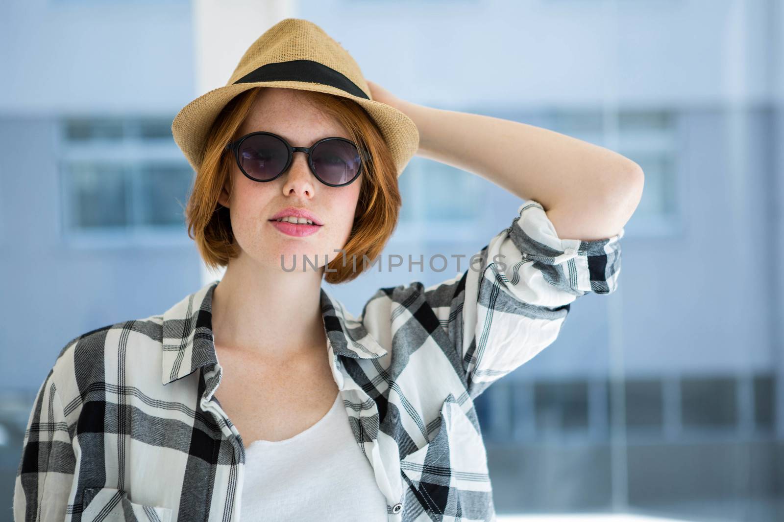 Fashion hipster wearing sunglasses in front of a window