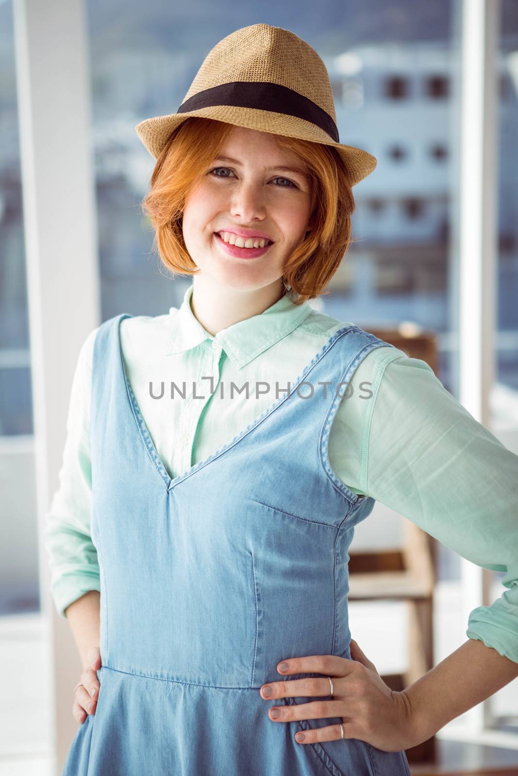 Fashion hipster wearing a hat in front of a window