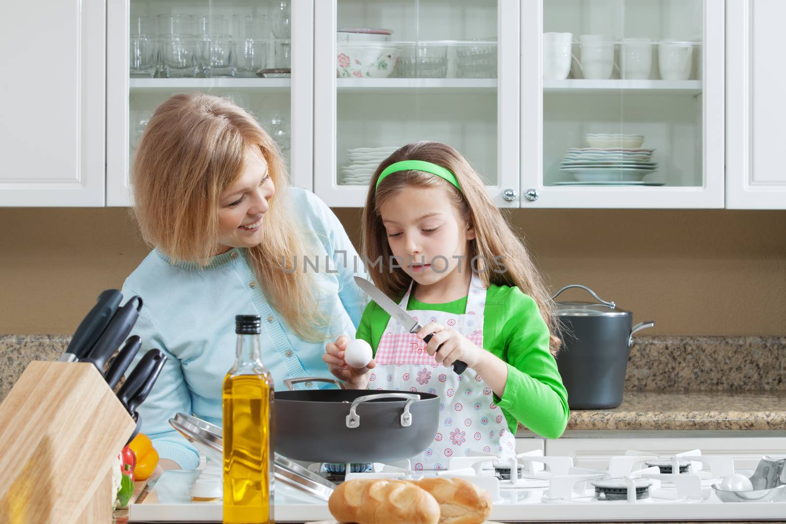 view of young beautiful girl cooking at the kitchen with her mama