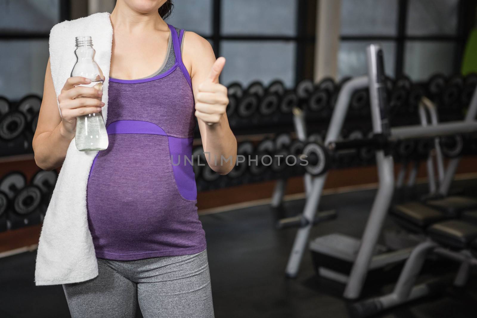 Mid section of pregnant woman showing thumb up by Wavebreakmedia