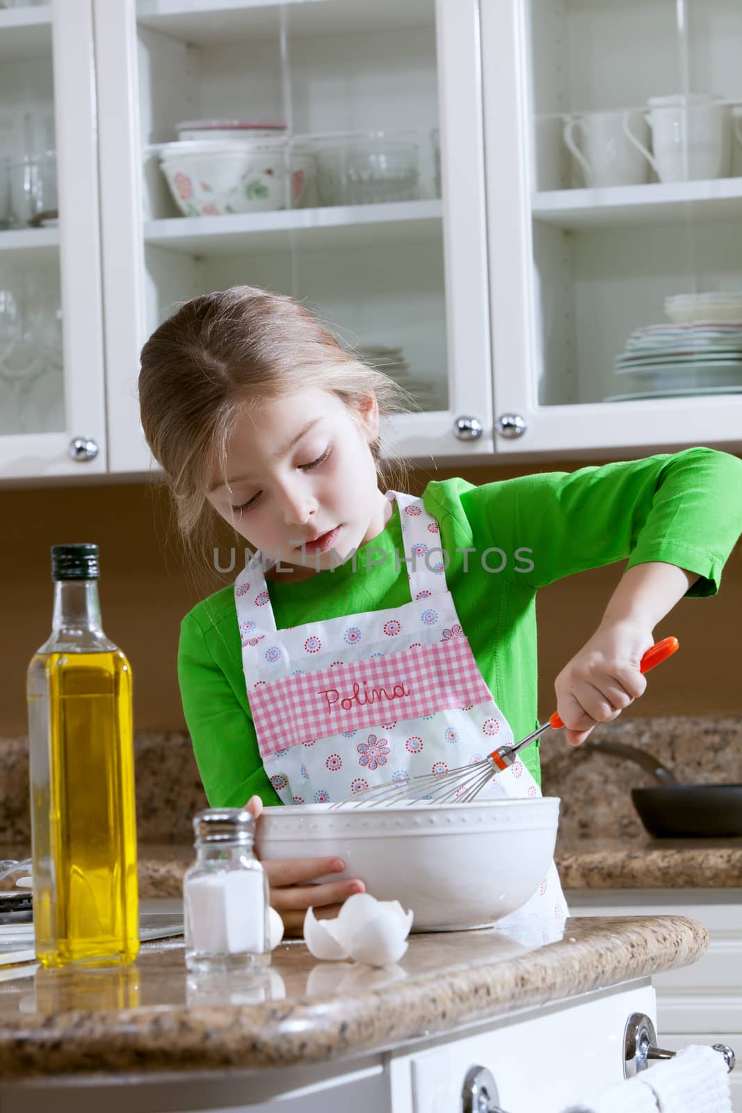 view of young beautiful girl cooking at the kitchen