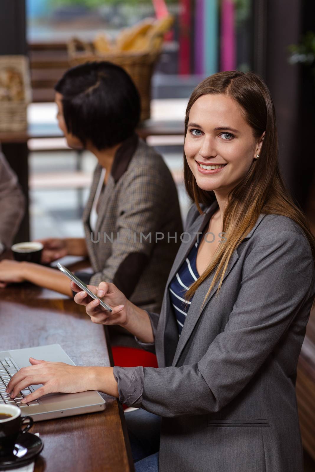 Smiling woman using smartphone in a cafe