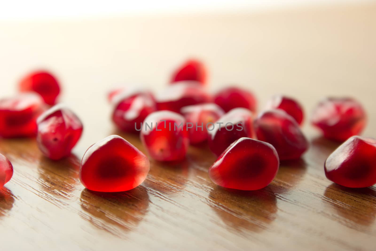 ripe, red garnets' seeds on wooden table
