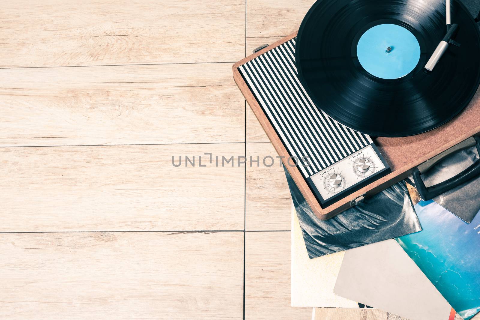 Gramophone with a vinyl record on wooden table, top view and copy space,photo desaturate and split toning for old style.