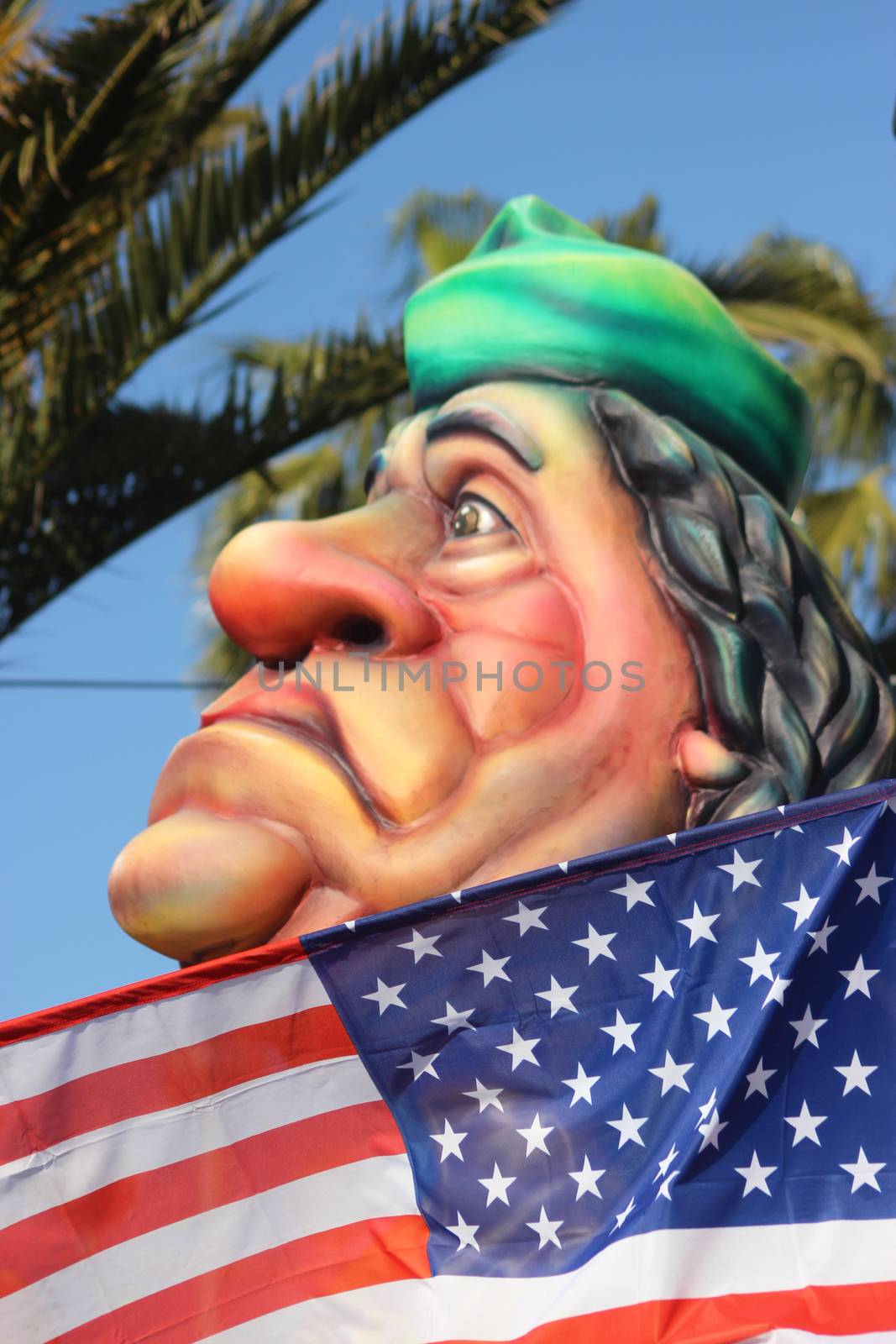 Nice, France - February 21 2016: Caricature of Muammar Gaddafi behind the American flag (Colonel Gaddafi). Parade Float during the Carnival of Nice (Corso Carnavalesque 2016) in French Riviera. The Theme for 2016 was King of Media