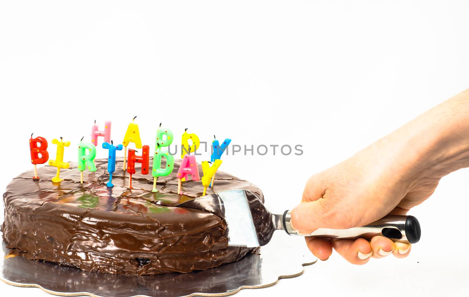 Female person cutting a homemade sacher chocolate cake with birthday candles