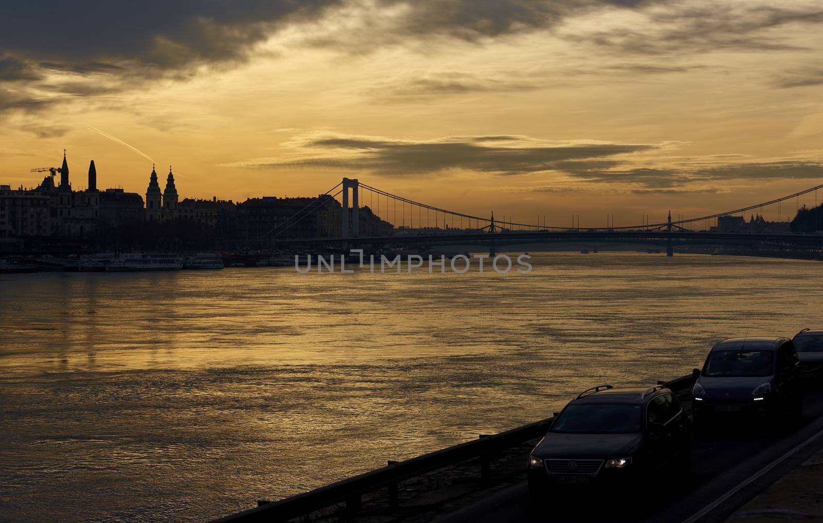 BUDAPEST, HUNGARY - FEBRUARY 02: Semi-silhouette of traffic by Danube River, with orange sunrise in the background. February 02, 2016 in Budapest.
